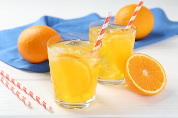 Refreshing soda water with orange slices in glasses and fresh fruits on white wooden table, closeup