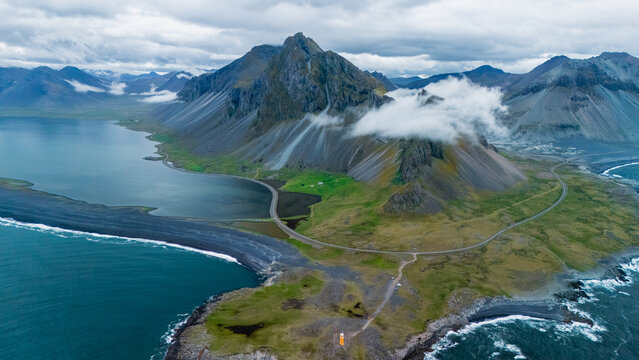 Discover the awe-inspiring beauty of Iceland, showcasing dramatic mountains, lush greenery, and tranquil coastal waters. Perfect for nature lovers seeking adventure and serene landscapes.