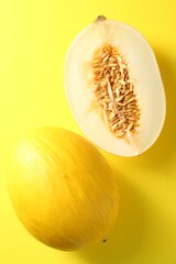 Fresh ripe melons on yellow background, flat lay