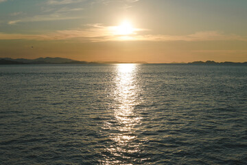 Fototapeta premium Morning view of Labuan Bajo seascape with the sun setting over the ocean.