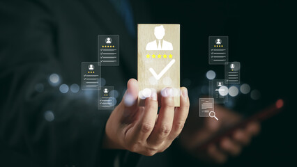 Businessman hand holding wooden block with smiley face and five star rating, concept of customer satisfaction, positive feedback, online review, quality service, and successful business reputation.