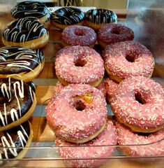 Chocolate and strawberry donuts - A variety of colorful donuts, including chocolate and strawberry frosted with sprinkles