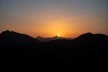yellow and orange sunrise with layers of the mountains in Damüls Bregenzer Wald in Vorarlberg Austria seen from Portlahorn with negative space for text