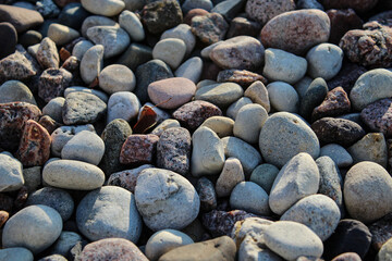 River rock with a single leaf. These rocks are commonly used in landscaping and outdoor design.  Background with copy space