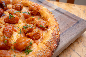 Imagen horizontal de un plano a detalle de una rica pizza de boneless de pollo con salsa picante