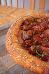 Imagen a detalle vertical de una deliciosa pizza de boneless sobre una tabla de madera