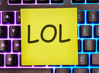LOL. written on a yellow sticker on a laptop keyboard with backlight