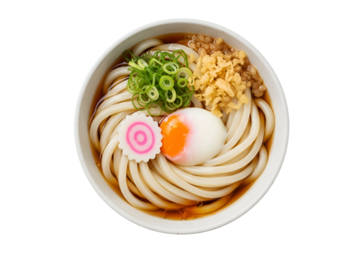 Delicious bowl of udon noodle soup topped with an soft boiled egg green onions and tempura bits