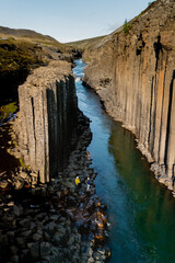 Experience the breathtaking geological formations of Studlagil Canyon in Iceland, where towering...