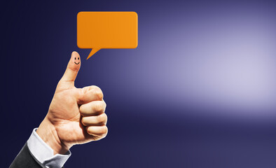 Human hand showing thumbs up with smiley face on thumb and orange speech bubble on gradient...