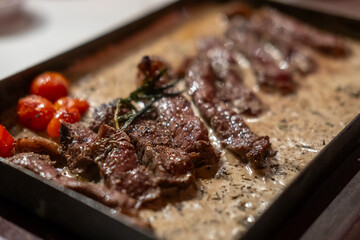 Medium rare grilled meat with gravy sauce on pan