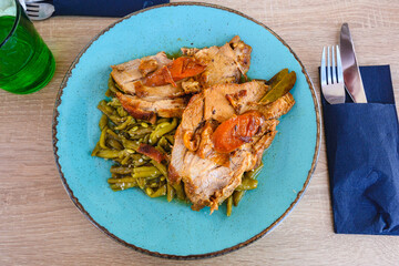 A piece of stewed pork served with green beans in Croatian restaurant