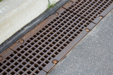 Cast Iron gully drain cover on urban street. Protection against storm and rain