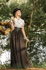 Fototapeta premium Gorgeous Victorian Blonde Woman with book in the Forest.Vintage