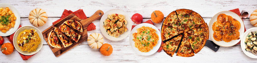 Delicious autumn meal table scene. Top down view on a white wood banner background. Pumpkin and...