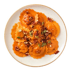 Pumpkin filled ravioli pasta with nuts and pumpkin seeds. Overhead view isolated on a white background. Autumn meal.