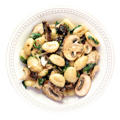 Gnocchi with a mushroom cream sauce, spinach, chicken and sun dried tomatoes. Above view isolated on a white background. Autumn meal.