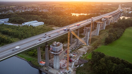 Highway bridge construction site over the Kiel Canal, with traffic moving on the existing lanes...