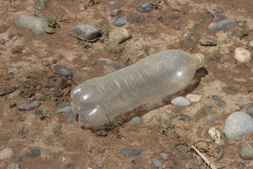 A plastic bottle lying on the ground, Plastic pollution