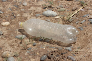 A plastic bottle lying on the ground, Plastic pollution