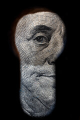 Benjamin Franklin looking through the keyhole, closeup. The eye of the president of America on the...