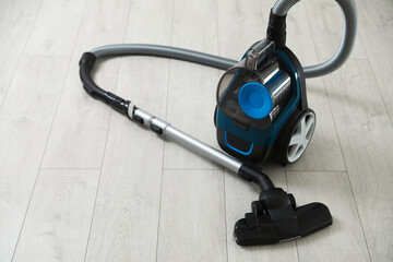 One vacuum cleaner on wooden floor. Household appliance