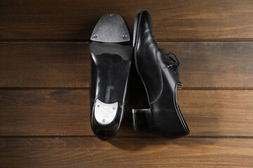 Pair of tap shoes on wooden floor, top view. Tap dance