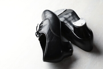Pair of shoes for tap dance on white wooden floor, closeup. Space for text