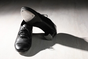 Pair of shoes for tap dance on white wooden floor. Space for text