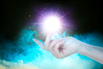 Woman creating bright light in smoke against black background, closeup. Aura, spiritual practice