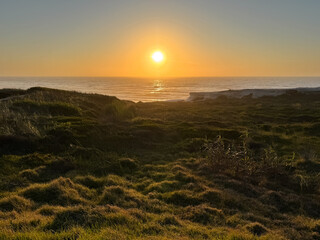 Sunset over coastal hills and serene ocean view