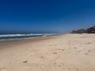 Expansive sandy beach with blue ocean waves view