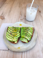 Avocado toast and refreshing drink on wooden table