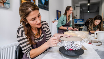 In an art studio with an environment adorned with artistic paintings in the background, a beautiful...