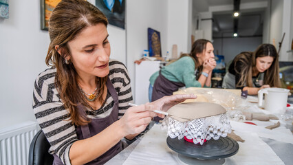 In an art studio with an environment adorned with artistic paintings in the background, a beautiful...