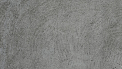 Gray cement plaster wall with visible trowel marks and rough surface texture. Minimalist background ideal for architectural, industrial, or abstract design use.