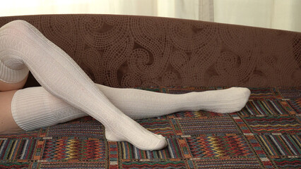 Women's legs in white stockings.