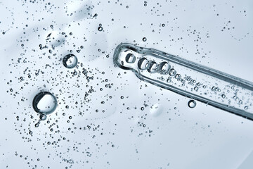 The texture of hyaluronic serum with lots of bubbles with a pipette.