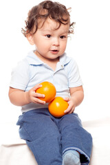 Cute curly haired toddler eating fresh and healthy fruit
