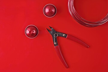 Crafting with coffee capsules. Homemade jewelry on red background.