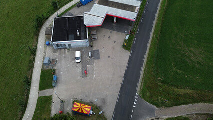 Aerial view of a gas station with a car wash, a car, a mini circus snack tent, drone photography