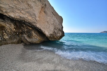 Skalisty klfi, schodzący do samego morza. Plaża Myrtos na greckiej wyspie Kefalonia,  uważana za jedną z dziesięciu najpiękniejszych świata