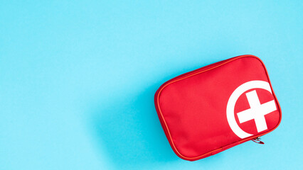 Close-up of a first aid kit on a pastel blue background. When preparing for a trip, take a first...