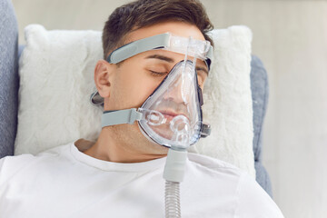 Male patient wearing medical face oxygen mask, breathing oxygen gas for lungs, ventilation and...