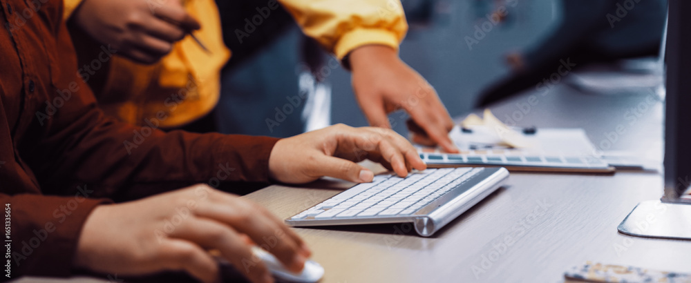 Poster a creative team collaborates on a project in a modern office. one person types on a keyboard, while 