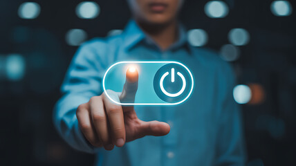 A persons finger touches a glowing power button on a digital interface, signifying the start of a technological process or system