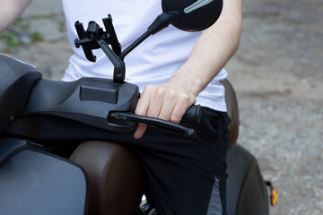 A young man on a motor scooter on a city street.