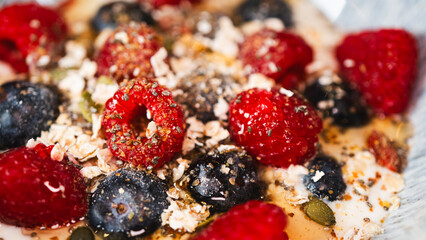 Nutritious yogurt parfait with fresh raspberries, blueberries, oats, chia seeds and honey drizzle. Perfect for healthy food blogs and breakfast photography.