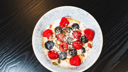 Nutritious yogurt parfait with fresh raspberries, blueberries, oats, chia seeds and honey drizzle. Perfect for healthy food blogs and breakfast photography.