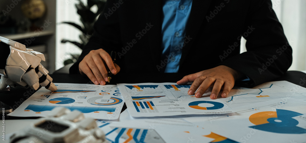 Poster a business professional uses a robotic arm to analyze financial reports and charts, showcasing moder